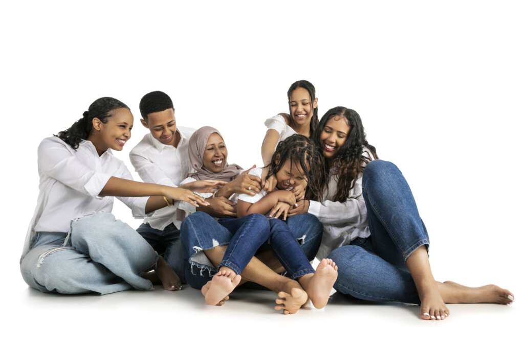 A large family group tickling a younger member of the family
